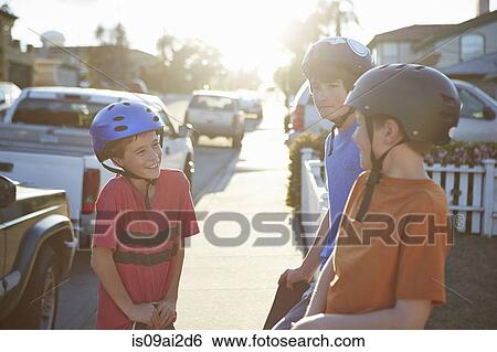 Stock Photograph - Boys wearing helmets talking. Fotosearch