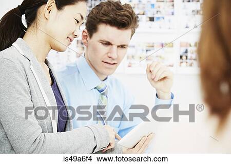 Business colleagues in discussion with digital tablet View Large Photo Image Picture - Business colleagues in discussion with digital tablet. Fotosearch
