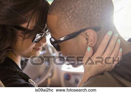 Stock Image - Close up of tender young couple face to face in car. Fotosearch
