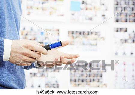 Close up of young man holding pen, gesturing View Large Photo Image Stock Image - Close up of young man holding pen, gesturing. Fotosearch