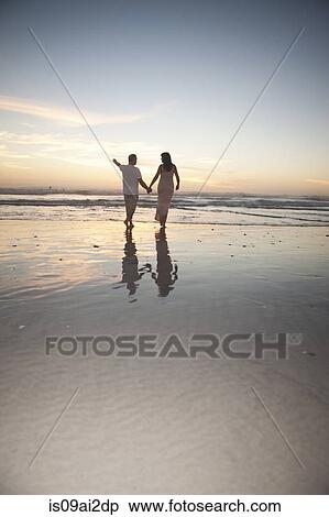 Couple holding hands on beach at sunset, Cape Town, South Africa View Large Photo Image Stock Photography - Couple holding hands on beach at sunset, Cape Town, South Africa. Fotosearch