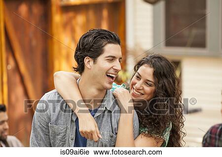 Couple in garden, with arm around, friends in background View Large Photo Image Stock Image - Couple in garden, with arm around, friends in background. Fotosearch