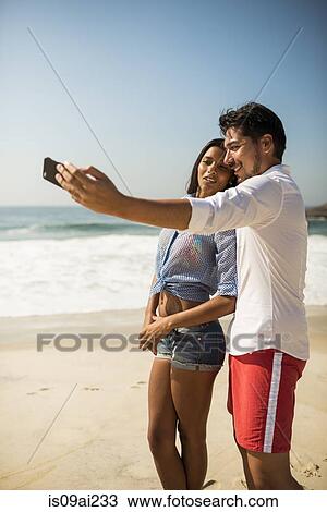 Couple taking self portrait on smartphone, Arpoador beach, Rio De Janeiro, Brazil View Large Photo Image Stock Image - Couple taking self portrait on smartphone, Arpoador beach, Rio De Janeiro, Brazil. Fotosearch