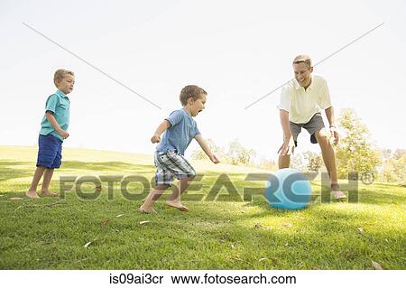 Father and sons playing ball at park View Large Photo Image Stock Photography - Father and sons playing ball at park. Fotosearch