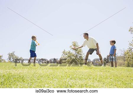 Father and sons playing baseball at park View Large Photo Image Picture - Father and sons playing baseball at park. Fotosearch