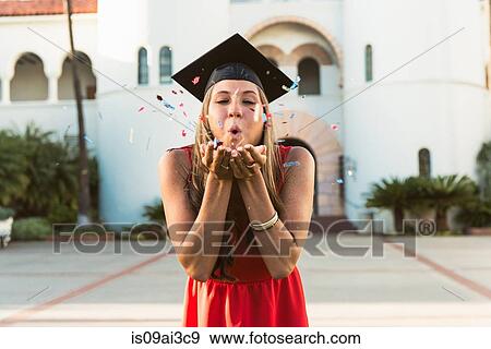 Female graduate blowing confetti from hands View Large Photo Image Stock Photo - Female graduate blowing confetti from hands. Fotosearch