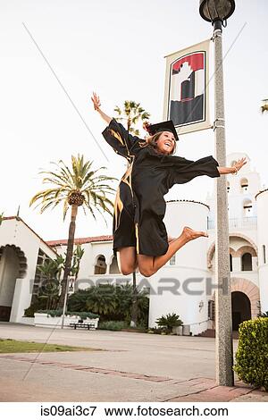 Stock Photo - Female graduate jumping for joy. Fotosearch