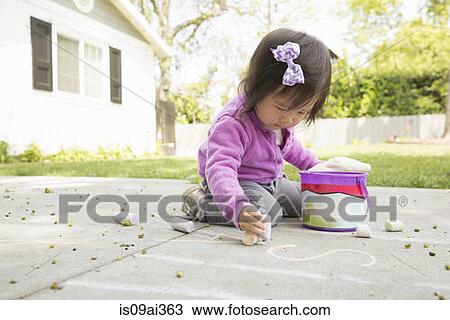 Female toddler playing with chalk on paving slabs View Large Photo Image Stock Image - Female toddler playing with chalk on paving slabs. Fotosearch