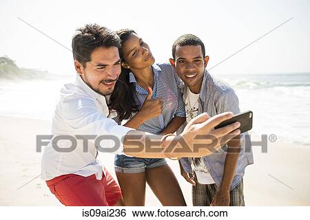 Friends taking self portrait on smartphone, Arpoador beach, Rio De Janeiro, Brazil View Large Photo Image Stock Photograph - Friends taking self portrait on smartphone, Arpoador beach, Rio De Janeiro, Brazil. Fotosearch