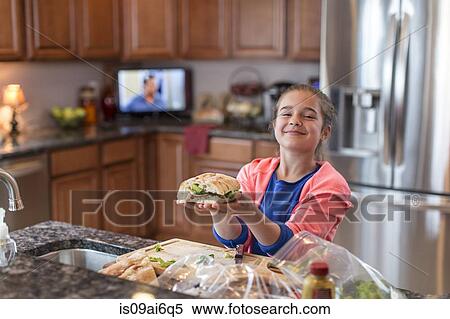 Stock Photography - Girl in kitchen preparing sandwich. Fotosearch