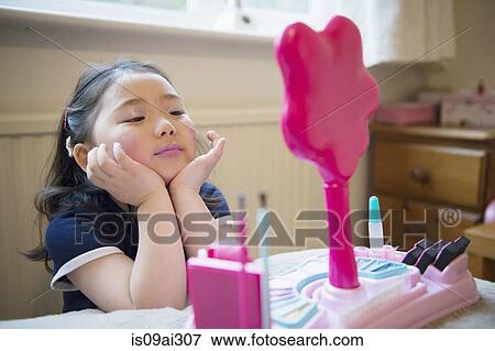 Girl putting make up on View Large Photo Image Stock Photo - Girl putting make up on. Fotosearch
