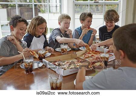 Stock Image - Group of boys sharing pizza. Fotosearch