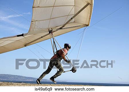 Hang glider pilot taking off View Large Photo Image Stock Photo - Hang glider pilot taking off. Fotosearch