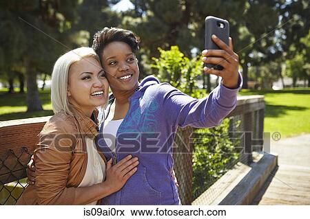 Lesbian couple posing for self portrait in park View Large Photo Image Stock Photo - Lesbian couple posing for self portrait in park. Fotosearch