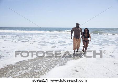 Mature couple walking on beach View Large Photo Image Stock Image - Mature couple walking on beach. Fotosearch