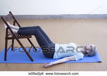 Mature woman resting legs on chair View Large Photo Image Stock Photograph - Mature woman resting legs on chair. Fotosearch