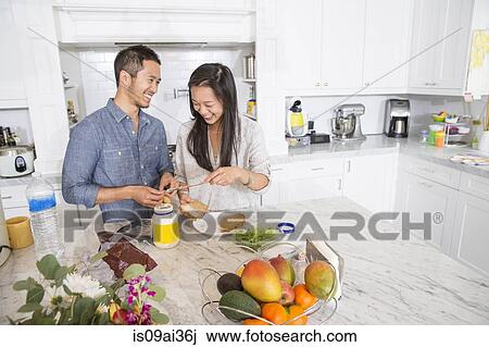 Mid adult couple preparing sandwich in kitchen View Large Photo Image Stock Image - Mid adult couple preparing sandwich in kitchen. Fotosearch