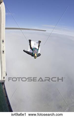 Mid adult man flying above clouds in wingsuit View Large Photo Image Stock Image - Mid adult man flying above clouds in wingsuit. Fotosearch