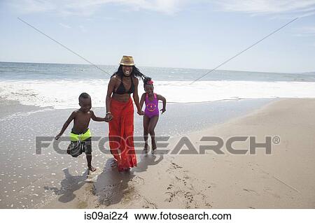 Picture - Mother and children walking on beach. Fotosearch