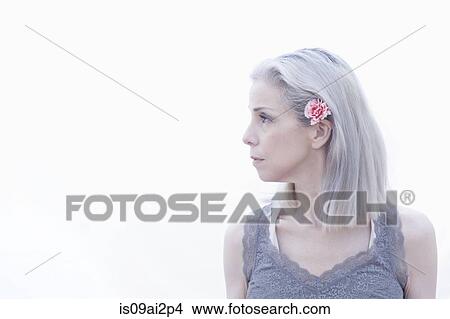 Picture - Portrait of mature woman with flower in hair. Fotosearch