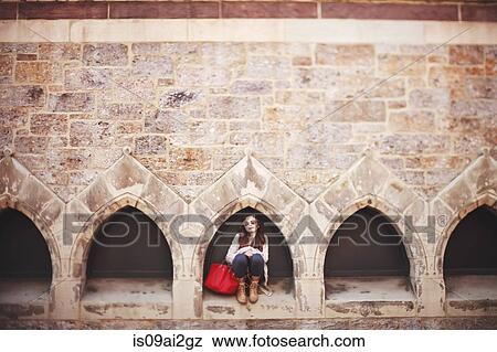 Portrait of young woman crouching in arch doorway View Large Photo Image Stock Photo - Portrait of young woman crouching in arch doorway. Fotosearch