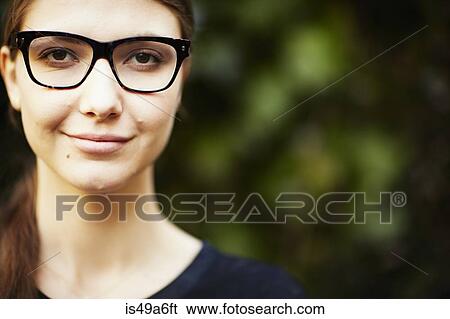 Stock Photograph - Portrait of young woman wearing glasses. Fotosearch