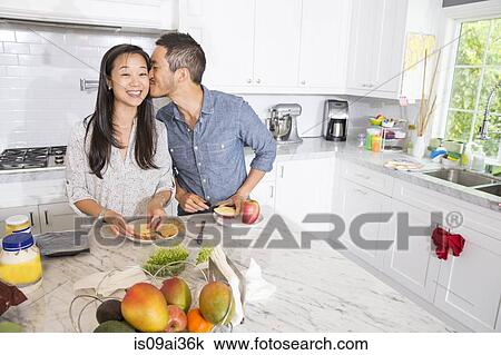 Romantic mid adult couple preparing sandwich at kitchen counter View Large Photo Image Stock Image - Romantic mid adult couple preparing sandwich at kitchen counter. Fotosearch