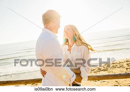 Romantic young couple with arms around each other at coast View Large Photo Image Picture - Romantic young couple with arms around each other at coast. Fotosearch