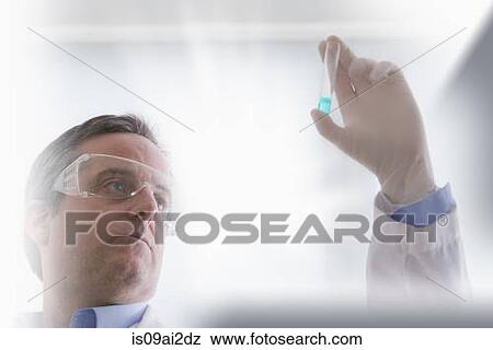 Scientist looking at test tube View Large Photo Image Stock Photo - Scientist looking at test tube. Fotosearch