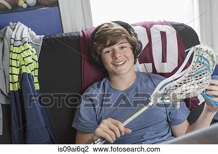 Stock Image - Teenage boy holding lacrosse stick. Fotosearch