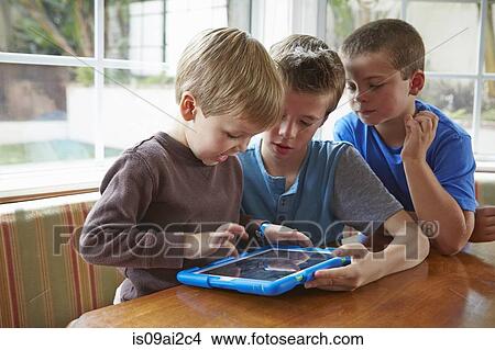 Three boys playing with digital tablet View Large Photo Image Picture - Three boys playing with digital tablet. Fotosearch