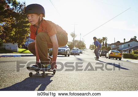 Two boys skateboarding on suburban road Stock Image | is09ai1tg | Fotosearch