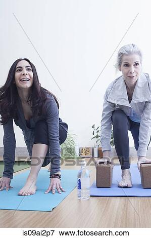 Women practising yoga View Large Photo Image Stock Photo - Women practising yoga. Fotosearch
