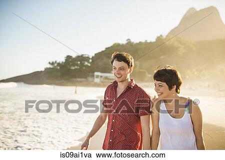 Stock Image - Young couple enjoying sunset, Ipanema Beach, Rio, Brazil. Fotosearch