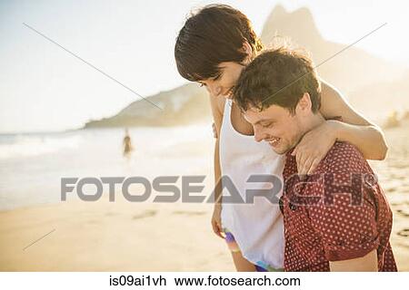 Stock Image - Young couple enjoying sunset, Ipanema Beach, Rio, Brazil. Fotosearch