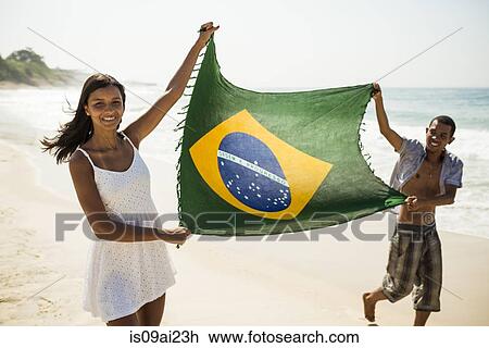 Young couple holding up Brazilian flag, Arpoador beach, Rio De Janeiro, Brazil View Large Photo Image Stock Image - Young couple holding up Brazilian flag, Arpoador beach, Rio De Janeiro, Brazil. Fotosearch