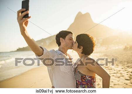 Young couple photographing themselves kissing, Ipanema Beach, Rio, Brazil View Large Photo Image Stock Image - Young couple photographing themselves kissing, Ipanema Beach, Rio, Brazil. Fotosearch