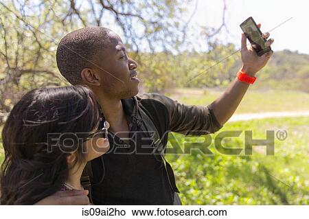 Young couple posing for self portrait in park View Large Photo Image Picture - Young couple posing for self portrait in park. Fotosearch