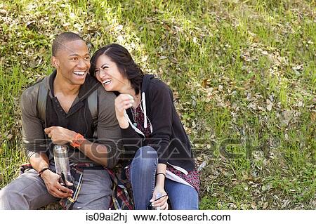 Young couple sitting on park grass View Large Photo Image Stock Image - Young couple sitting on park grass. Fotosearch