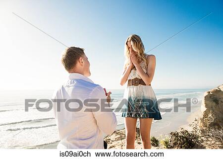 Stock Image - Young man proposing to girlfriend by sea, Torrey Pines, San Diego, California, USA. Fotosearch