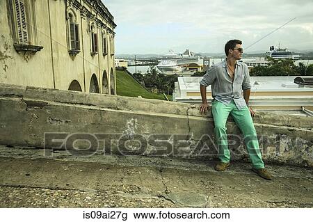 Young man sitting on wall next to Castillo San Felipe del Morro, Old San Juan, Puerto Rico View Large Photo Image Stock Image - Young man sitting on wall next to Castillo San Felipe del Morro, Old San Juan, Puerto Rico. Fotosearch