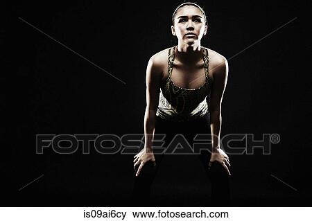 Young woman bending forwards, hands on knees View Large Photo Image Stock Photo - Young woman bending forwards, hands on knees. Fotosearch