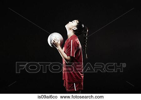Young woman holding football, looking up View Large Photo Image Picture - Young woman holding football, looking up. Fotosearch