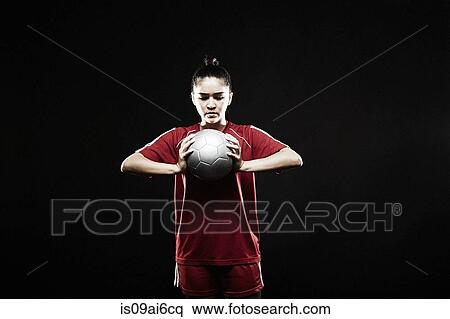 Stock Photography - Young woman holding football. Fotosearch