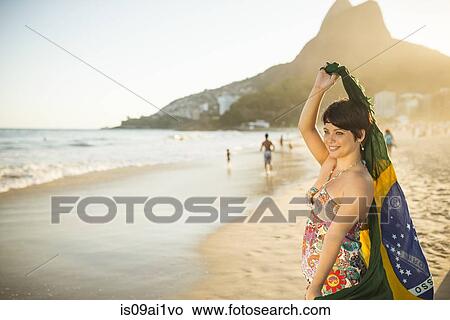 Young woman holding up Brazilian flag, Ipanema Beach, Rio, Brazil View Large Photo Image Picture - Young woman holding up Brazilian flag, Ipanema Beach, Rio, Brazil. Fotosearch