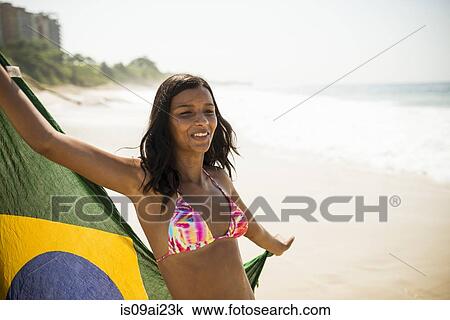Young woman holding up Brazilian flag, Arpoador beach, Rio De Janeiro, Brazil View Large Photo Image Stock Image - Young woman holding up Brazilian flag, Arpoador beach, Rio De Janeiro, Brazil. Fotosearch