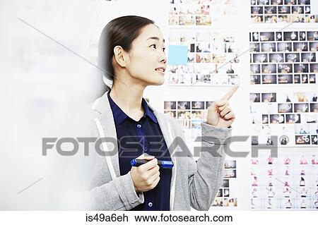 Young woman in creative studio, pointing View Large Photo Image Stock Image - Young woman in creative studio, pointing. Fotosearch