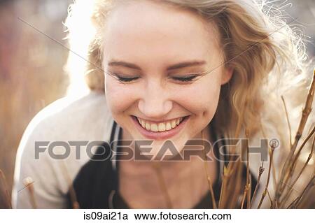 Young woman in long grass with eyes closed View Large Photo Image Stock Image - Young woman in long grass with eyes closed. Fotosearch