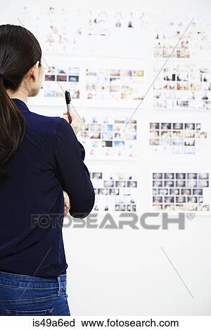 Young woman looking at photographs in studio View Large Photo Image Stock Image - Young woman looking at photographs in studio. Fotosearch
