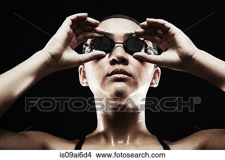Young woman putting on swimming goggles View Large Photo Image Picture - Young woman putting on swimming goggles. Fotosearch